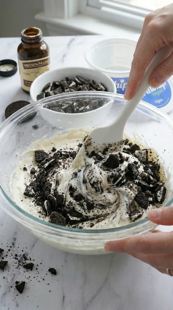 Folding crushed Oreos into dairy-free cheesecake dip