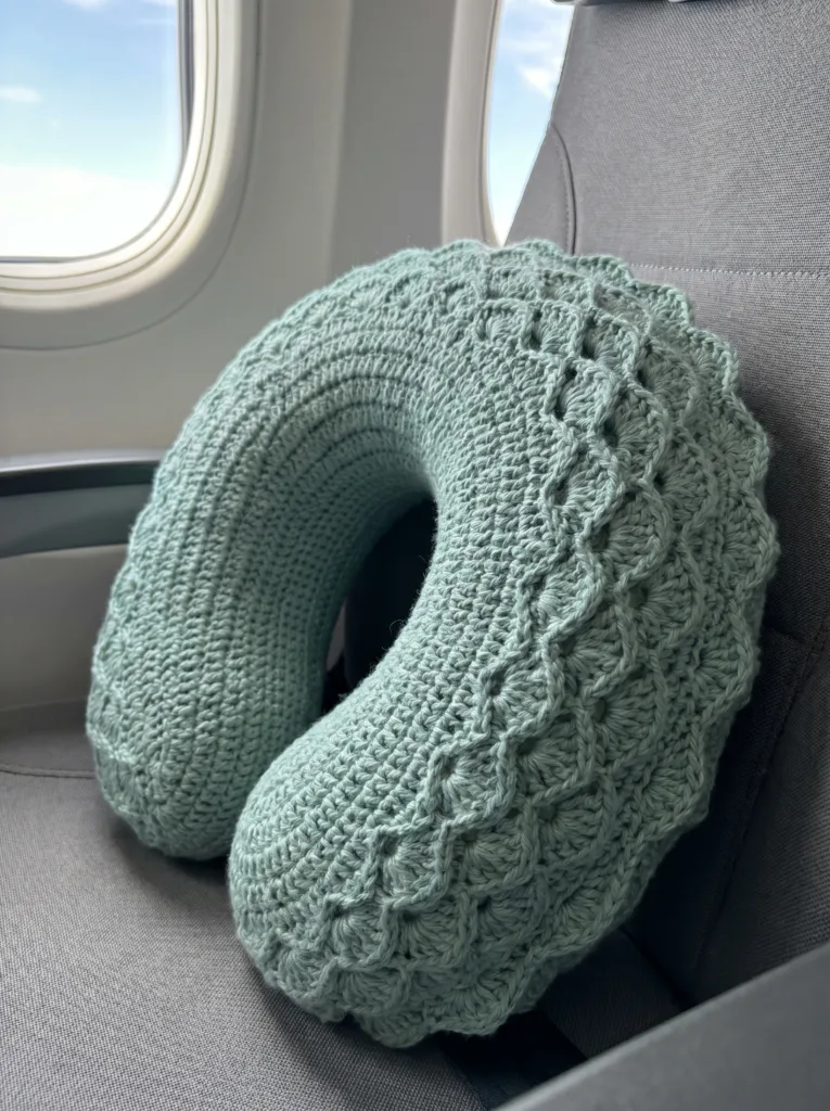 Seafoam green crochet U-shaped neck pillow cover with a raised shell-stitch dragon