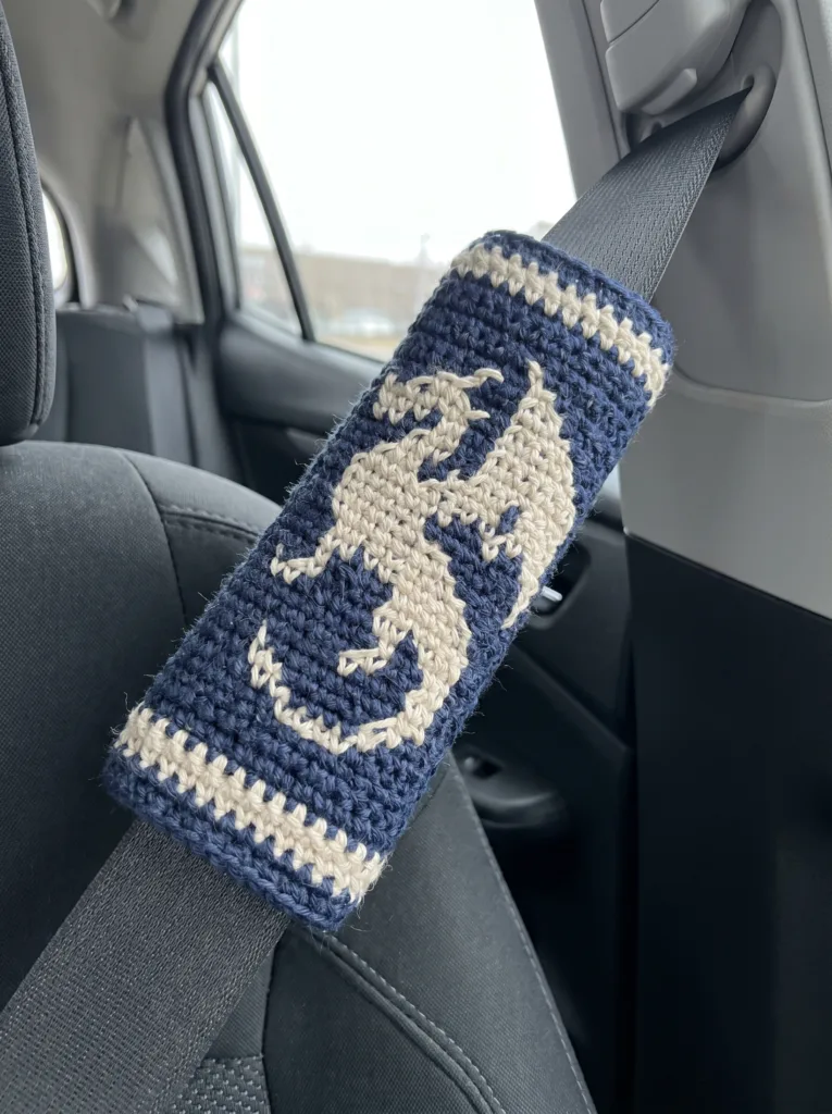 mosaic crochet seat belt shoulder cover with a cross-stitch-style anchor graphic