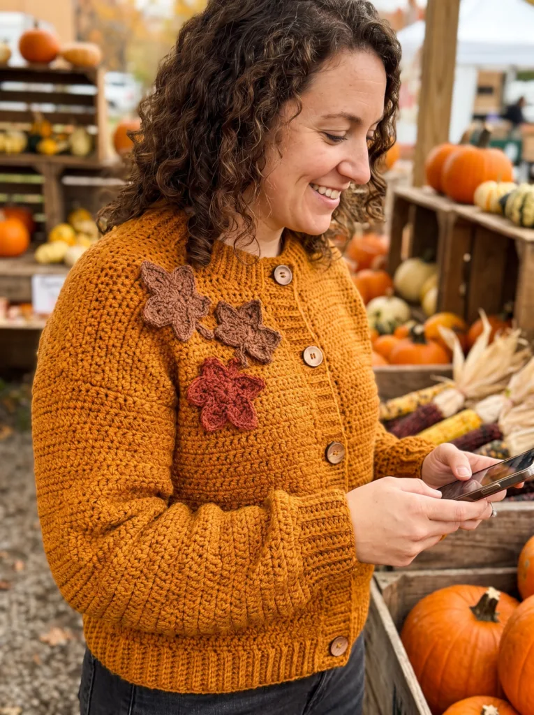 Crochet button-up cardigan in amber with maple leaf motifs and ribbed cuffs