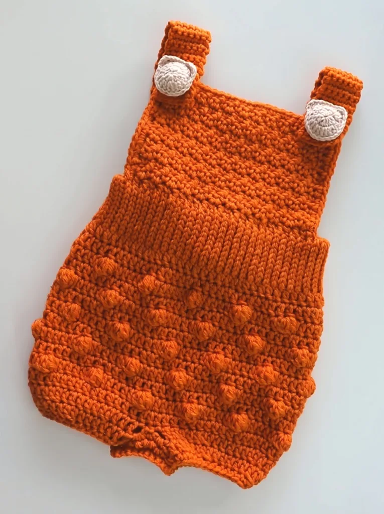 Crochet baby romper with cat buttons, textured autumn pattern